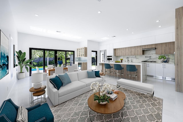 living room featuring light tile patterned flooring, sink, and french doors