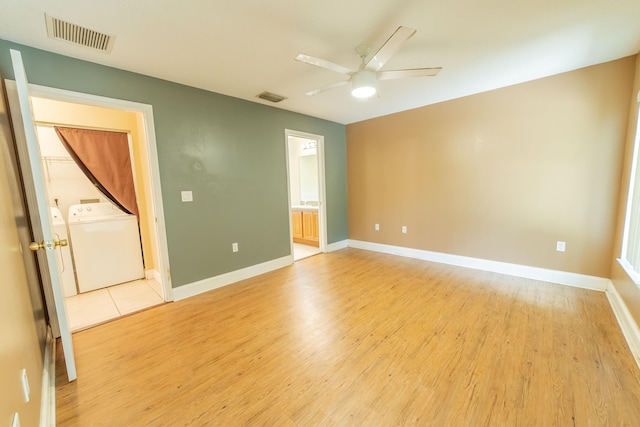 unfurnished bedroom featuring ensuite bath, light hardwood / wood-style flooring, independent washer and dryer, and ceiling fan