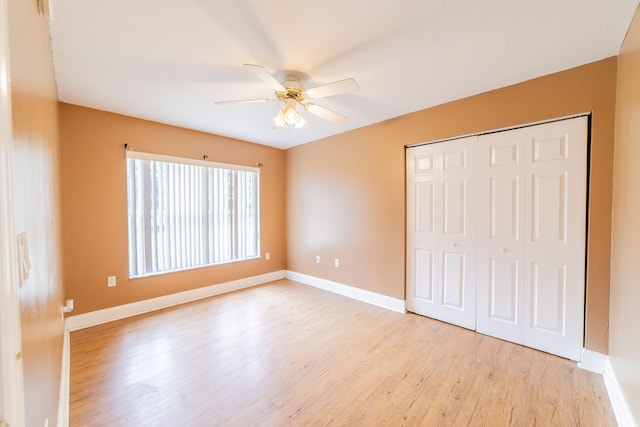 unfurnished bedroom with light hardwood / wood-style flooring, a closet, and ceiling fan