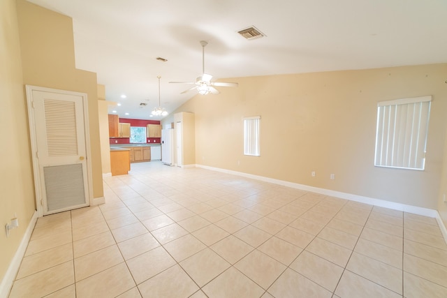 unfurnished living room with ceiling fan, light tile patterned flooring, and vaulted ceiling