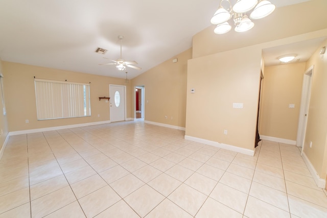 spare room with light tile patterned floors, vaulted ceiling, and ceiling fan with notable chandelier