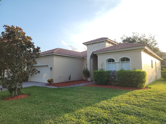 mediterranean / spanish-style house featuring a garage and a front lawn