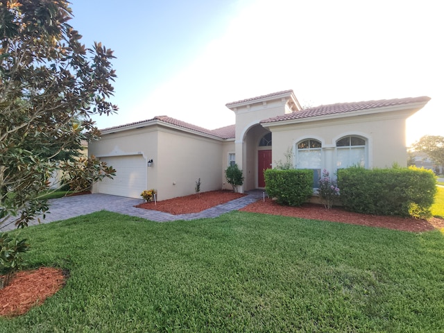 mediterranean / spanish house featuring a front yard and a garage