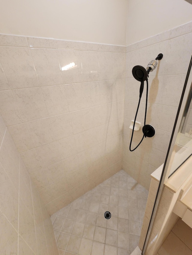 bathroom with vanity, tile patterned floors, and tiled tub