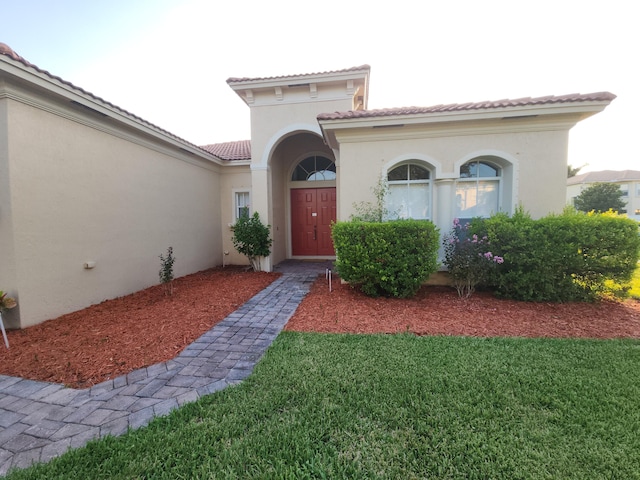 mediterranean / spanish house featuring a garage and a front lawn