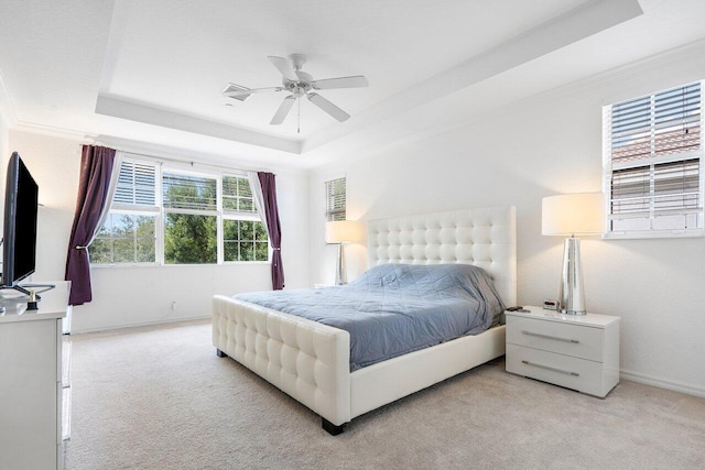 bedroom featuring a raised ceiling, ceiling fan, and light colored carpet