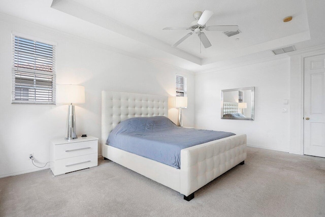 bedroom with a tray ceiling, ceiling fan, and light carpet