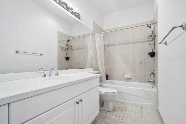 full bathroom featuring tile patterned flooring, vanity, toilet, and shower / bath combo with shower curtain