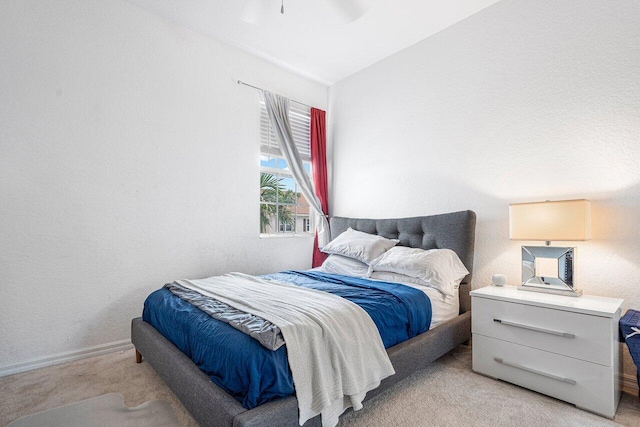 bedroom featuring ceiling fan, light carpet, and lofted ceiling