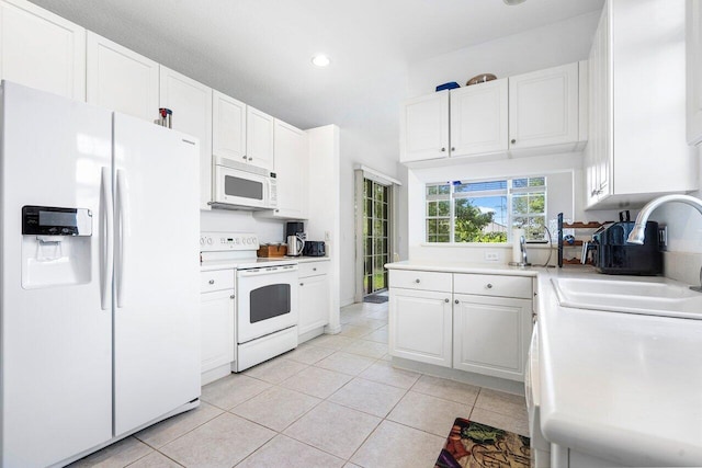 kitchen featuring white cabinets, light tile patterned floors, white appliances, and sink