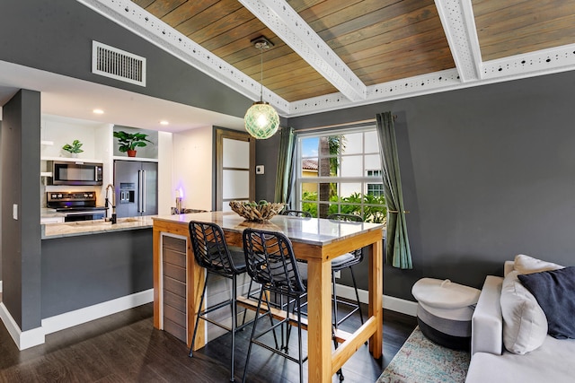 kitchen with dark hardwood / wood-style floors, hanging light fixtures, appliances with stainless steel finishes, wood ceiling, and lofted ceiling with beams