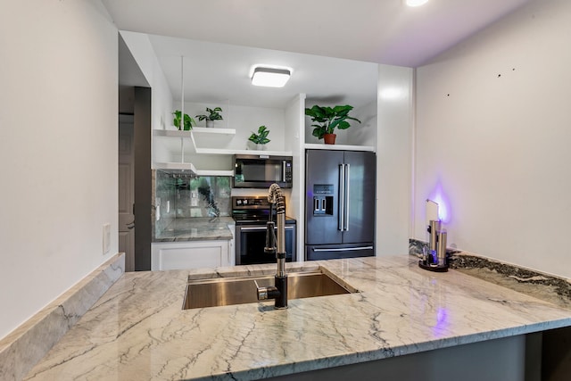 kitchen featuring light stone counters, appliances with stainless steel finishes, sink, and white cabinetry