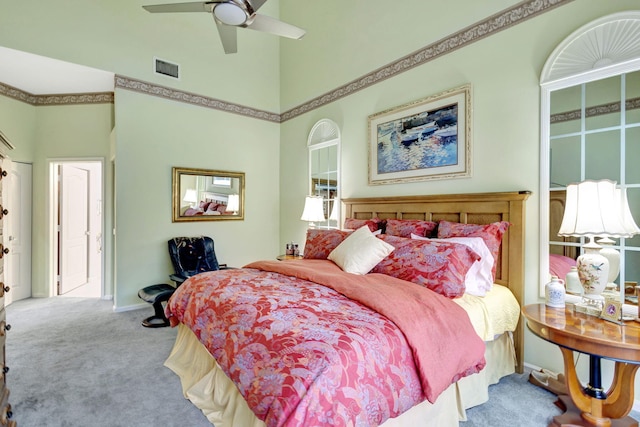 bedroom featuring ceiling fan, carpet floors, and a towering ceiling