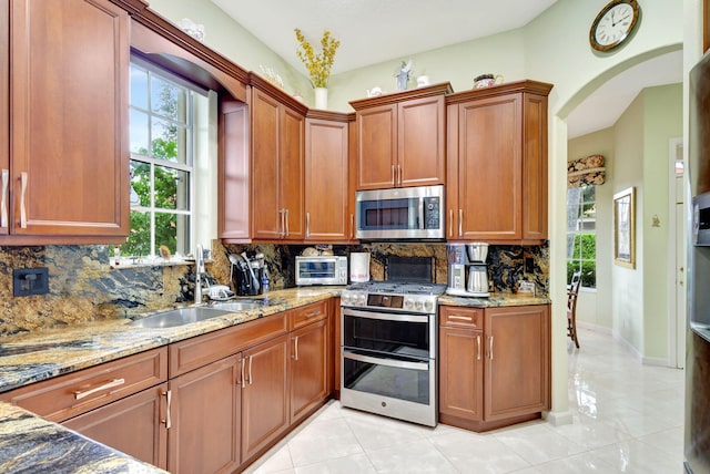 kitchen with backsplash, stainless steel appliances, and light tile patterned flooring