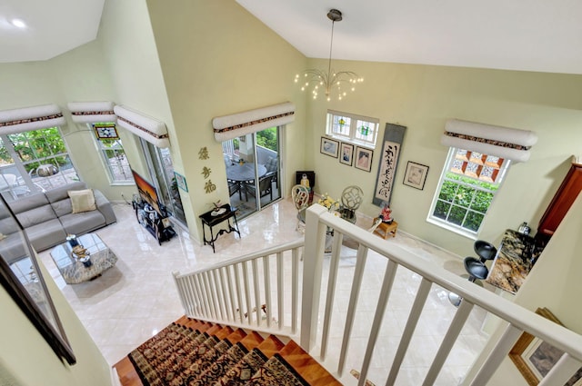 interior space with tile patterned flooring, plenty of natural light, high vaulted ceiling, and a chandelier