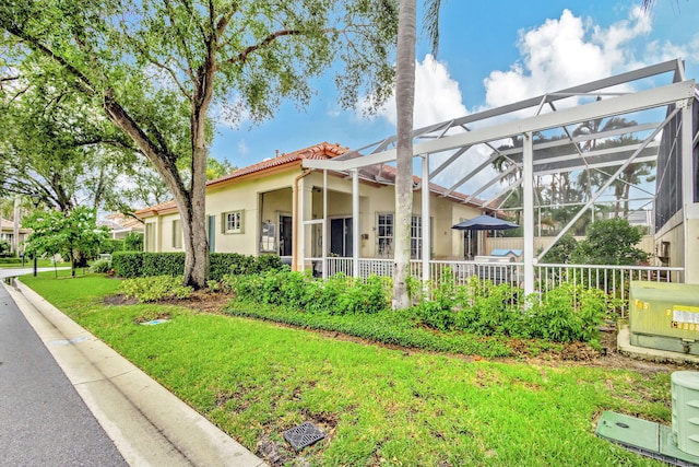 view of front facade featuring a lanai and a front yard