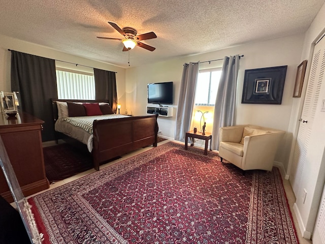 carpeted bedroom with ceiling fan, a textured ceiling, and a closet