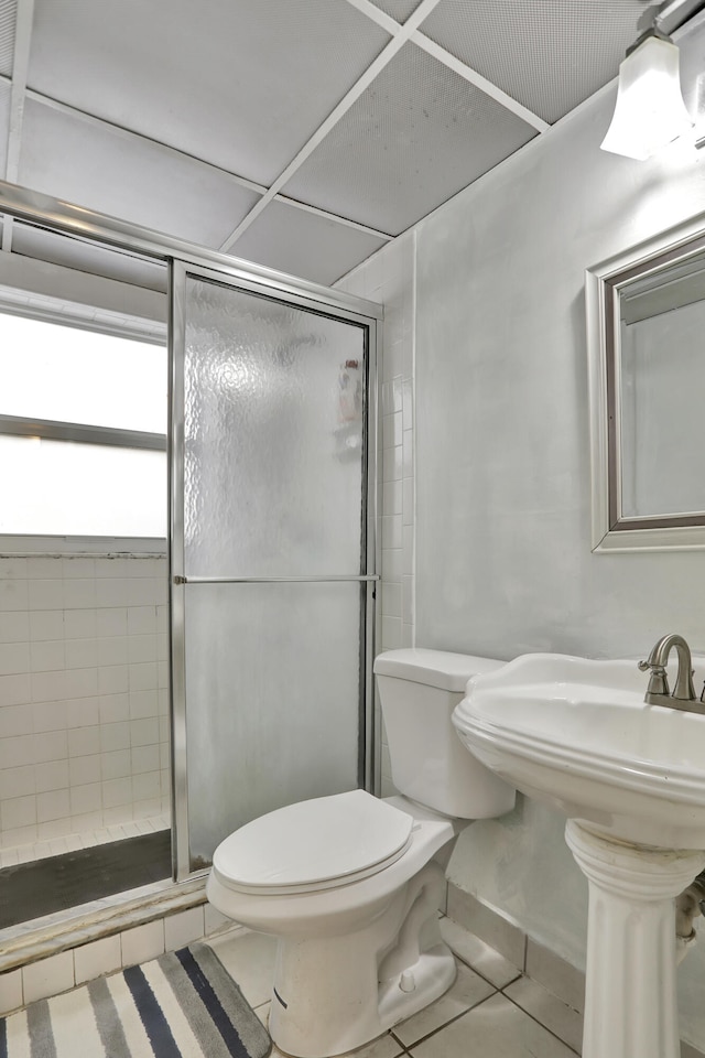 bathroom featuring an enclosed shower, tile patterned flooring, and toilet