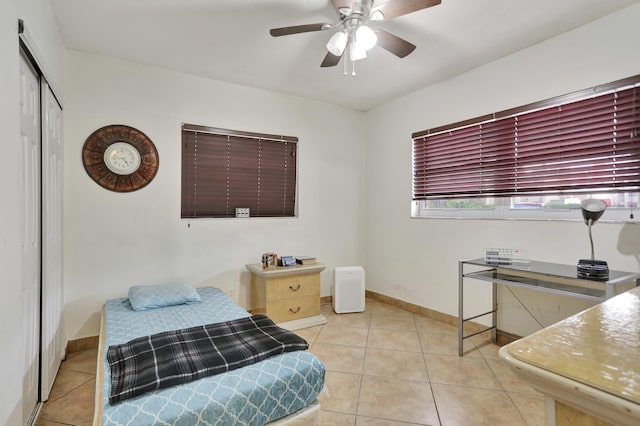 tiled bedroom featuring a closet and ceiling fan