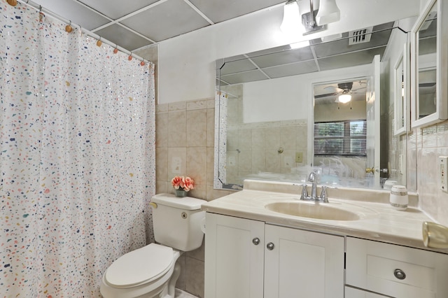 bathroom featuring ceiling fan, tile walls, vanity, and toilet