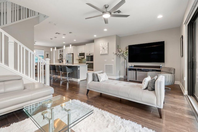 living room featuring hardwood / wood-style floors and ceiling fan