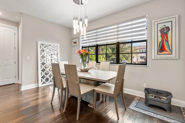 dining space featuring dark hardwood / wood-style floors and an inviting chandelier