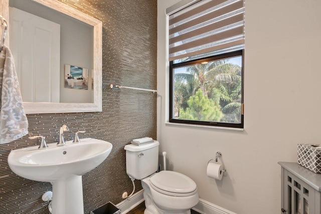 bathroom featuring decorative backsplash and toilet