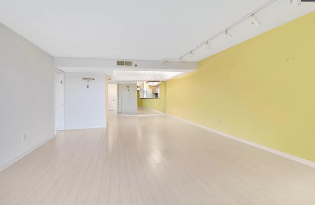 spare room featuring light hardwood / wood-style flooring and track lighting