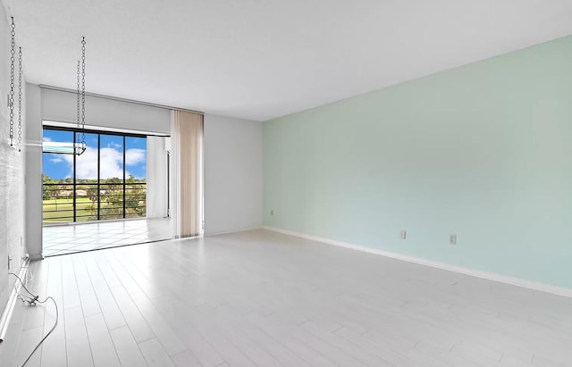 empty room with a chandelier and light hardwood / wood-style floors