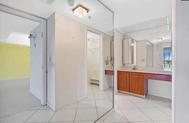 bathroom featuring tile patterned flooring, vanity, and a textured ceiling