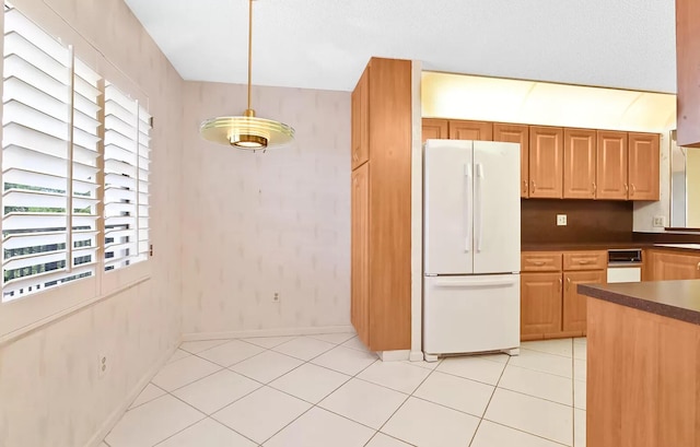 kitchen with decorative light fixtures, white fridge, and light tile patterned flooring