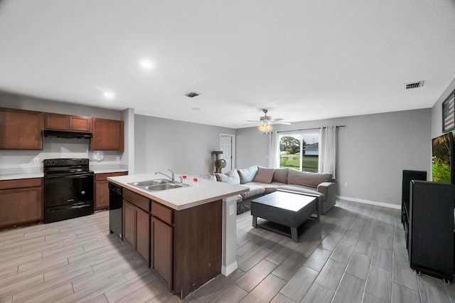 kitchen with a center island with sink, ceiling fan, light hardwood / wood-style flooring, black appliances, and sink