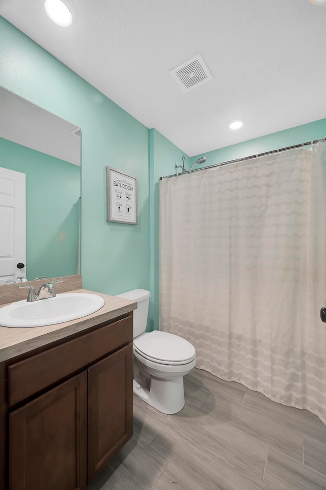 bathroom with vanity, a shower with shower curtain, wood-type flooring, and toilet