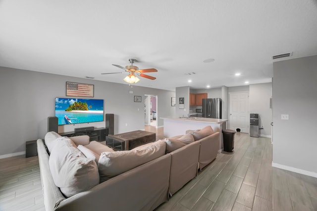 living room featuring ceiling fan and light hardwood / wood-style flooring