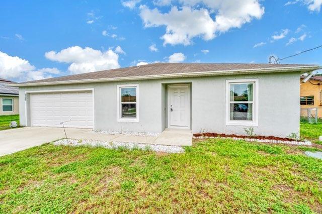 ranch-style home with a front lawn and a garage