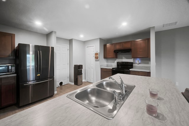 kitchen featuring sink, appliances with stainless steel finishes, and light hardwood / wood-style flooring