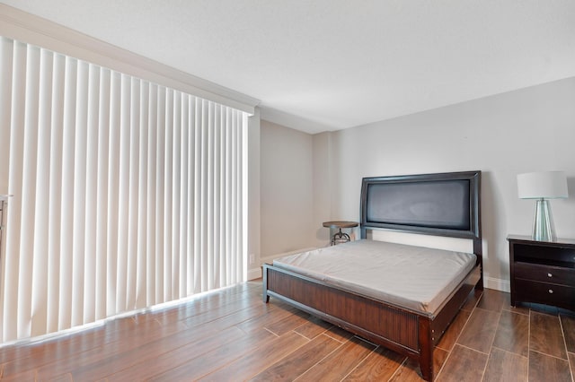 bedroom featuring wood finish floors and baseboards