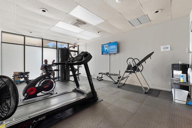 workout area featuring visible vents, floor to ceiling windows, a paneled ceiling, and baseboards