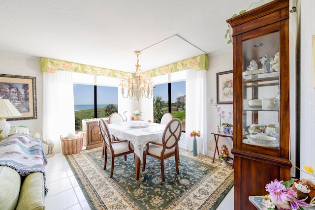 dining area with a notable chandelier, plenty of natural light, tile patterned floors, and a textured ceiling