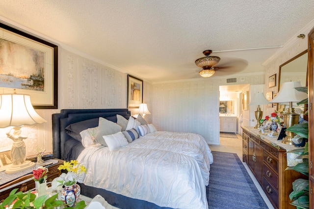 bedroom featuring ornamental molding, ensuite bath, a textured ceiling, and ceiling fan