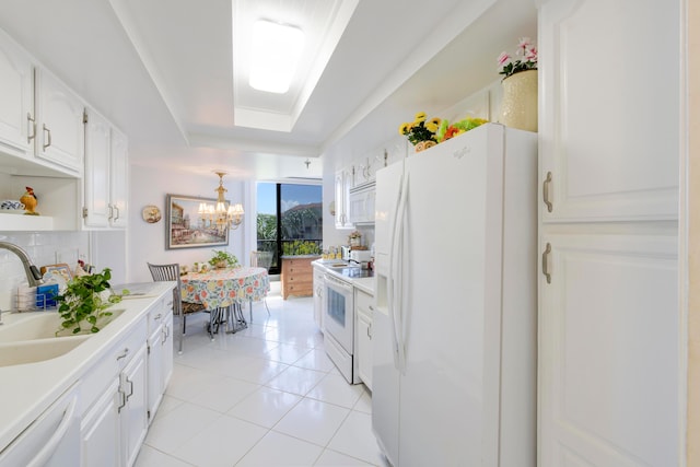 kitchen with white cabinets, white appliances, sink, decorative light fixtures, and light tile patterned floors