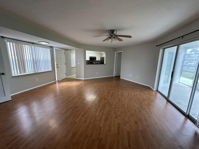 unfurnished living room featuring hardwood / wood-style floors and ceiling fan