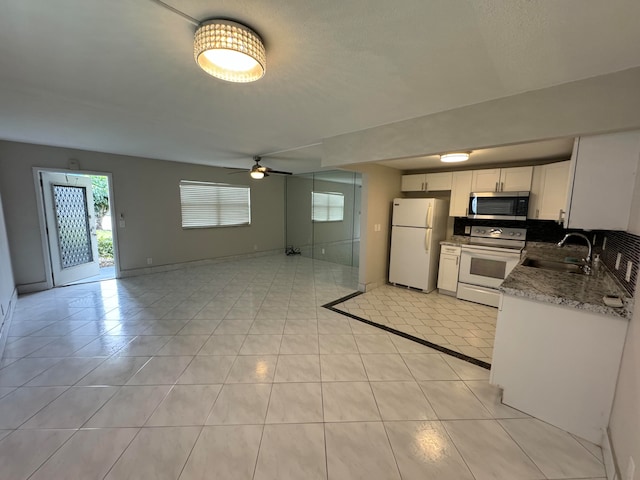 kitchen featuring white appliances, light tile patterned flooring, sink, ceiling fan, and white cabinets