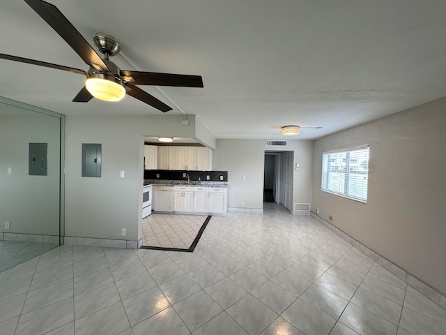 kitchen featuring light tile patterned floors, white cabinets, white dishwasher, ceiling fan, and electric panel