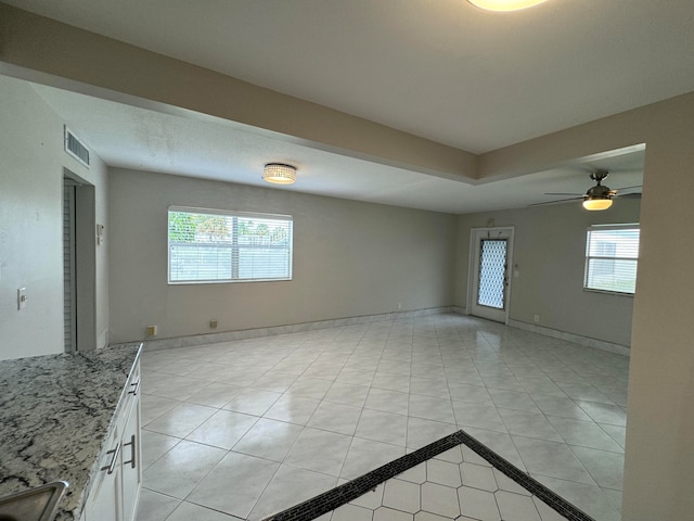 unfurnished room with light tile patterned floors and ceiling fan