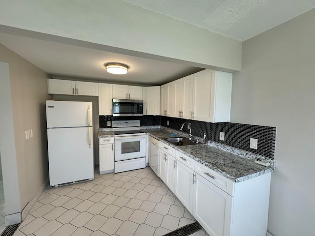 kitchen featuring white cabinets, sink, stone countertops, and white appliances