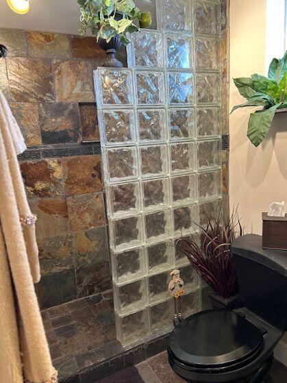 bathroom with tile patterned floors, toilet, and walk in shower