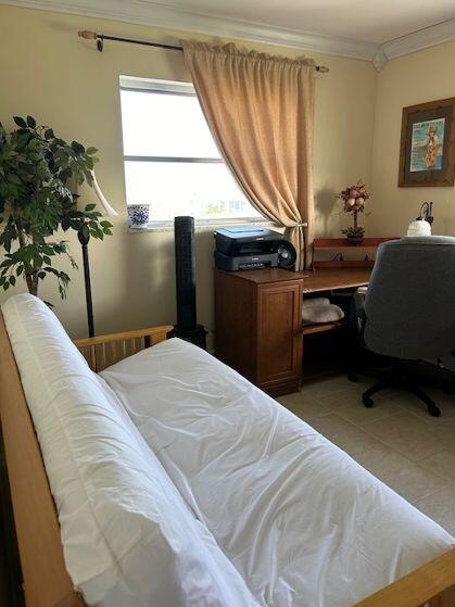 bedroom with crown molding and light tile patterned floors