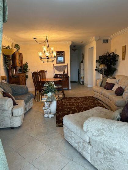 tiled living room with a notable chandelier and ornamental molding