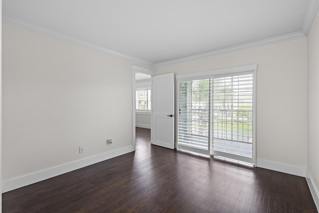 empty room with dark wood-type flooring, crown molding, and baseboards